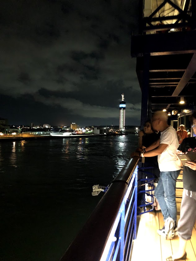 クルーズ船から夜の海を眺める人々